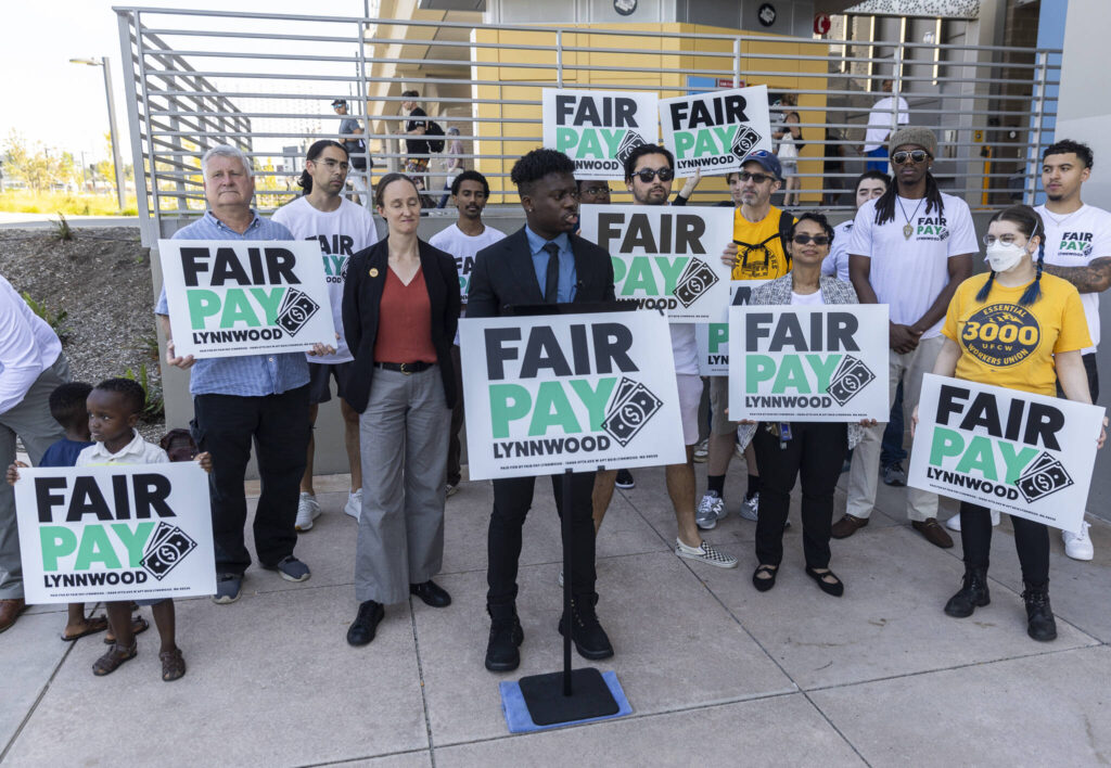 People gather for a Fair Pay Lynnwood rally while Lynnwood City Council Vice President Josh Binda speaks on Monday, Aug. 25, 2025, in Lynnwood, Washington. (Olivia Vanni / The Herald)
