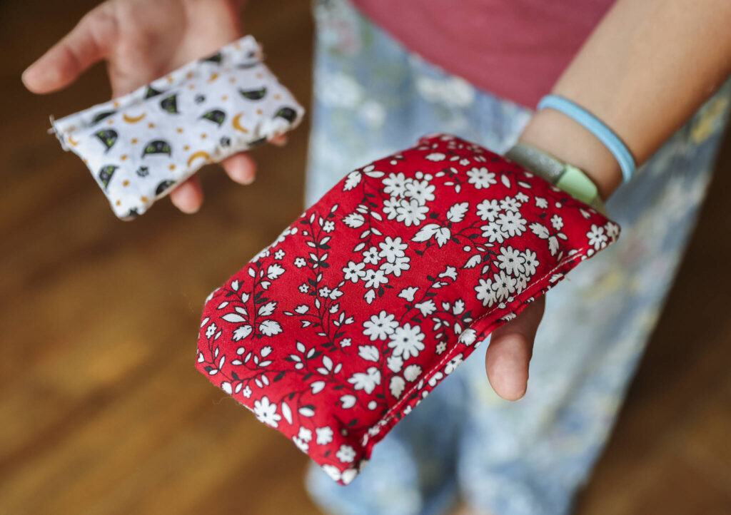 Eisley Lewis, 9, shows a rice bag and a lavender sachet she stitched and sold on Wednesday, Aug. 27, 2025, in Everett, Washington. (Olivia Vanni / The Herald)
