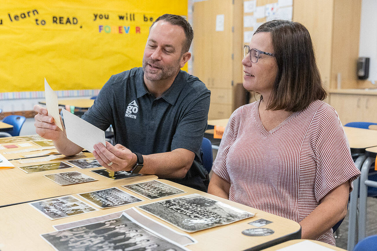North Middle School Principal Tyler Ream and teacher Jenny Overstreet look through historic photographs of North Middle School on Tuesday, Sept. 9, 2025 in Everett, Washington. (Olivia Vanni / The Herald)