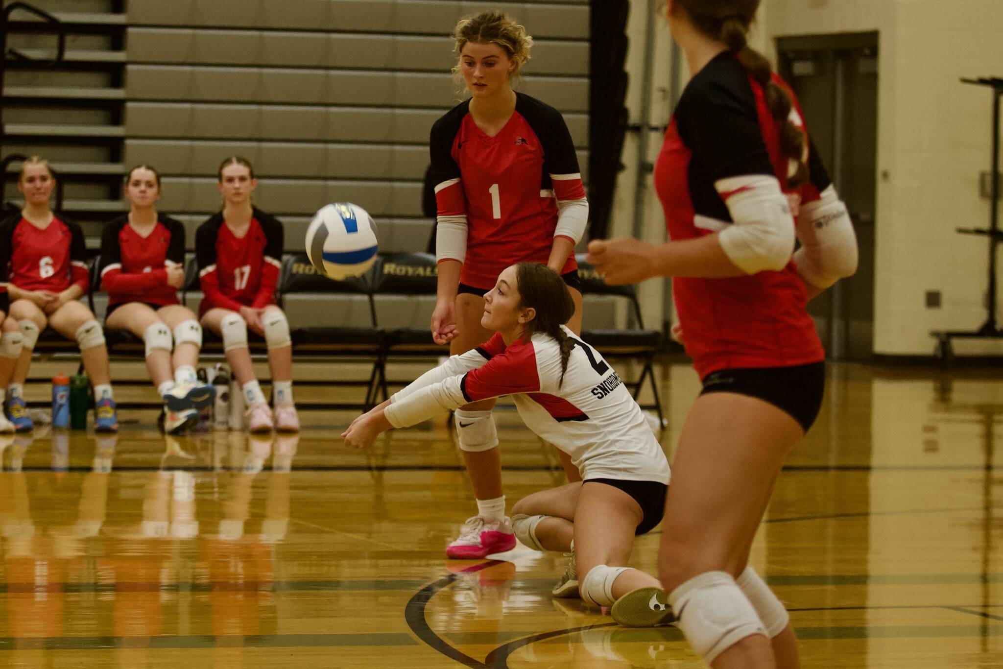 Snohomish junior Brooklyn Constance (center, in white) digs during the Panthers' 3-1 win against the Royals at Lynnwood High School on Sept. 9, 2025. (Joe Pohoryles / The Herald)