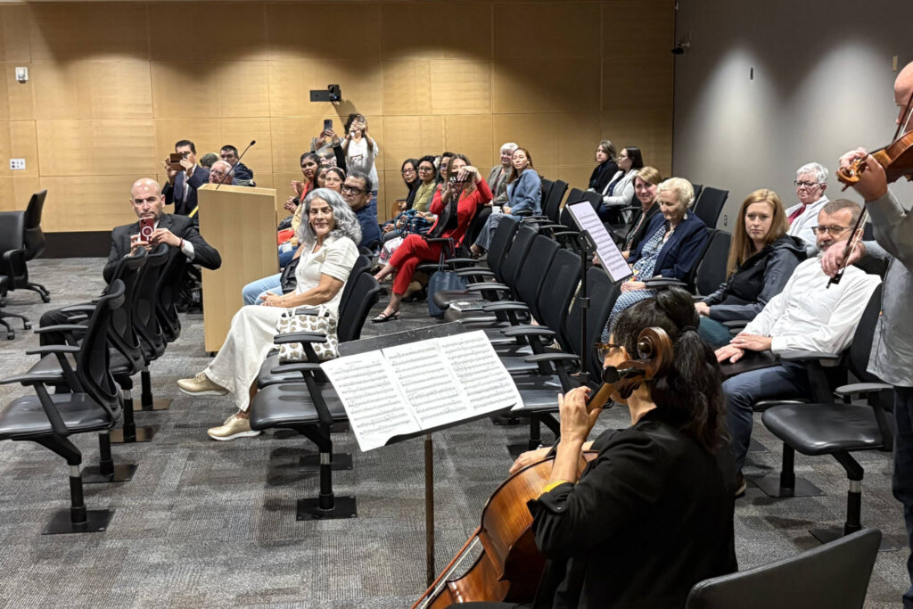 The group at the Snohomish County Council watches Paula Madrigal on cello and Teo Benson on violin perform “Mexican Overature” by Merle J. Isaac during a Snohomish County general legislative session on Wednesday, Sept. 10, 2025, in recognition of Hispanic Heritage Month in Everett, Washington. (Taylor Scott Richmond / The Herald)

