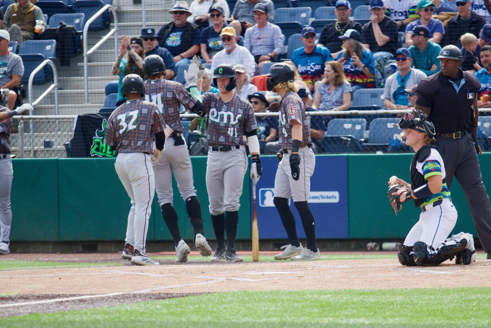 Emeralds third baseman Parks Harber (41) high-fives first baseman Charlie Szykowny (14) after Szykowny hit a three-run home run in the top of the first inning against the Everett AquaSox in Game 3 of the 2025 Northwest League Championship Series at Funko Field on Sept. 12, 2025. (Joe Pohoryles / The Herald)