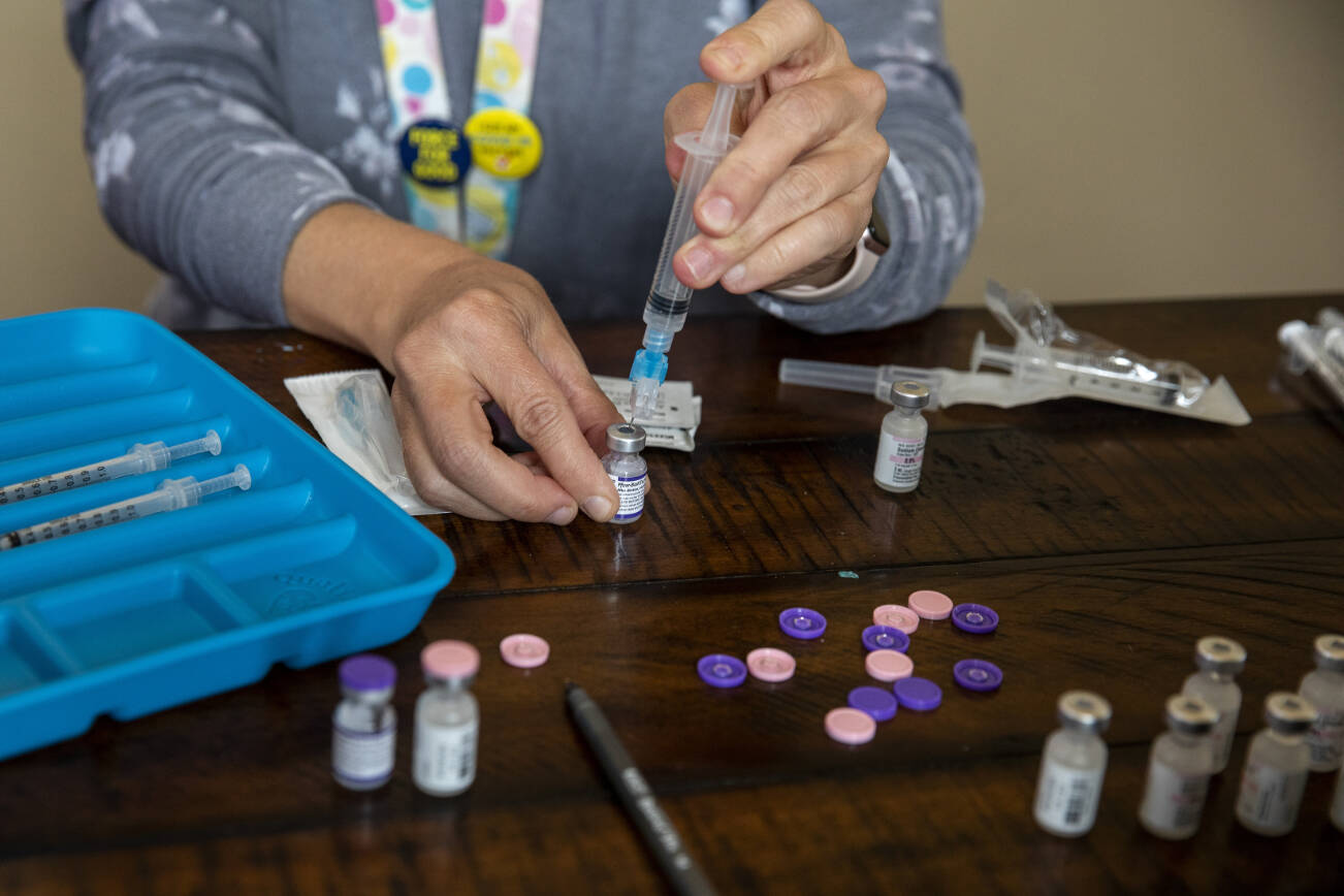 FILE — COVID19 vaccines are prepared by a nurse in a mobile vaccine clinic at a senior living facility in McMinnville, Ore., Oct. 6, 2021. A dozen public health experts, along with seven former high-ranking officials, are describing the CDC under the leadership of Robert F. Kennedy Jr. as badly wounded and fast losing its legitimacy, portending harsh consequences for public health. (Alisha Jucevic/The New York Times)