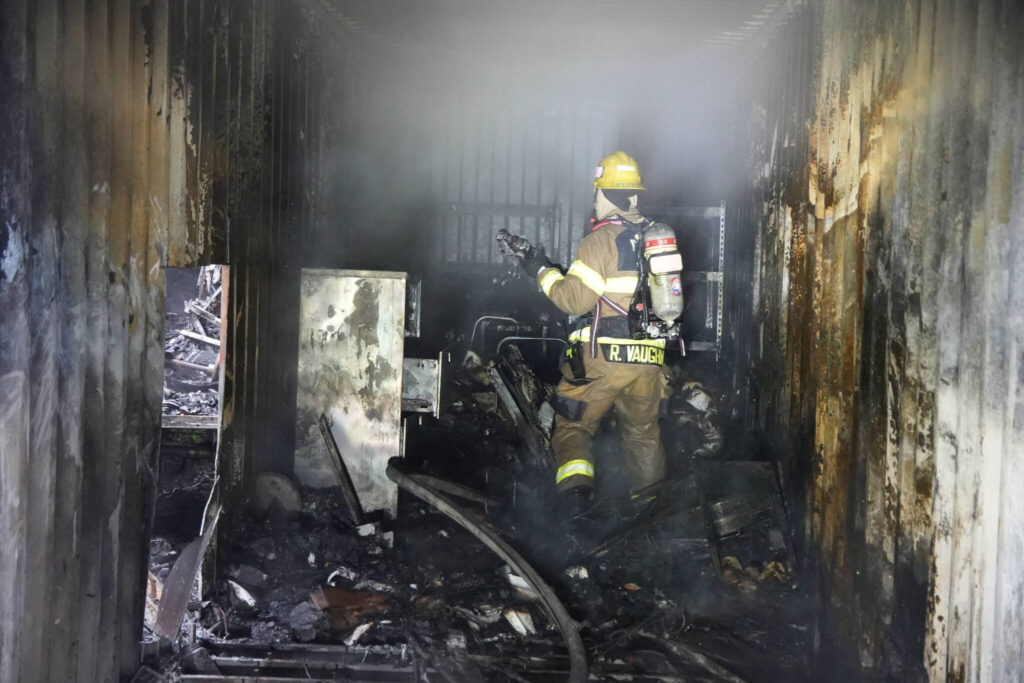 Firefighter inside a CONEX box on Sunday, Sep. 14, 2025, after a mobile home fire extended to a nearby structures in Monroe. (Snohomish Regional Fire and Rescue)
