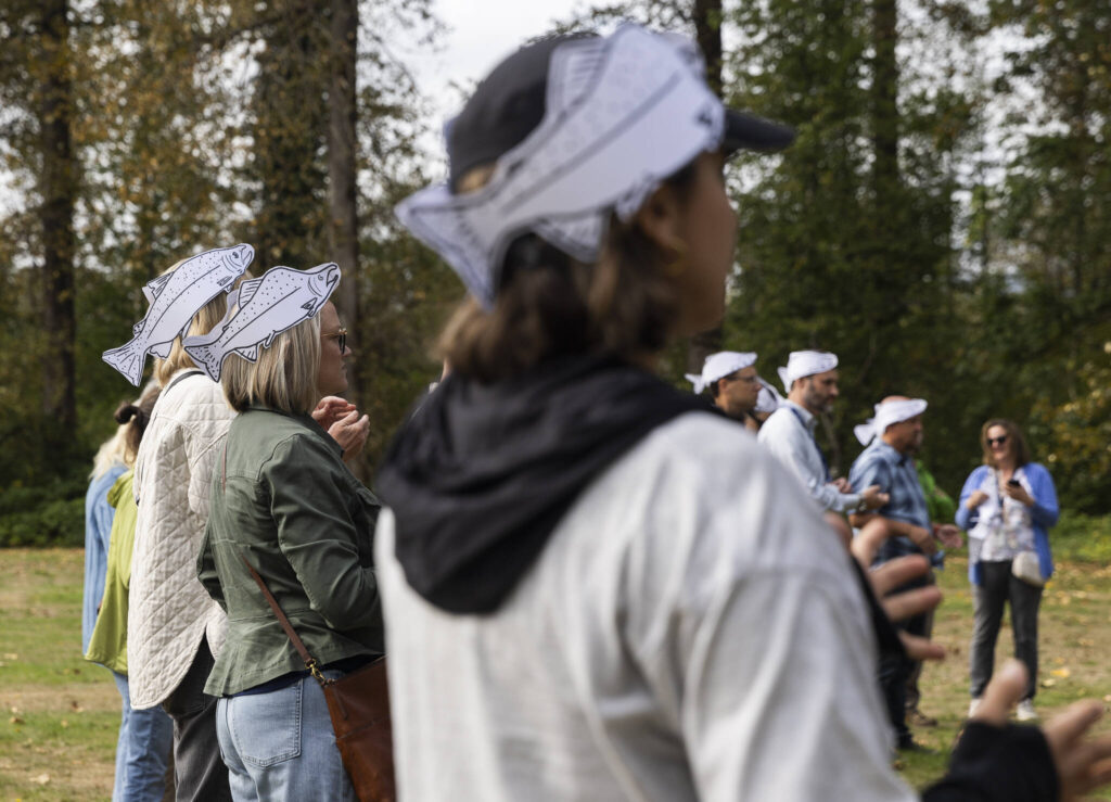 People wearing salmon hats gather for a ribbon cutting for a new side channel created in Osprey Park on Thursday, Sept. 18, 2025 in Sultan, Washington. (Olivia Vanni / The Herald)
