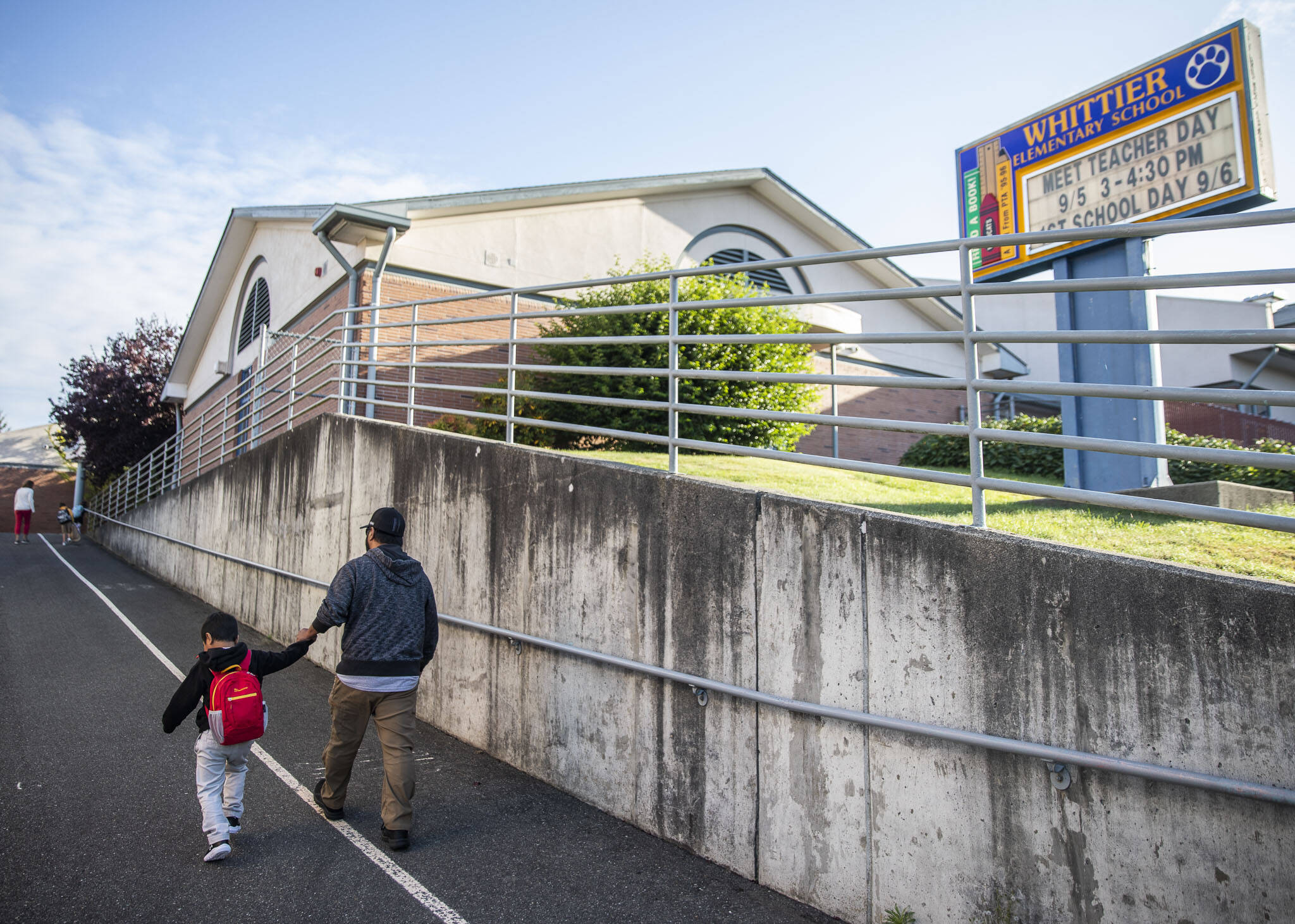 A parent walks their children to class at Whittier Elementary on Wednesday, Sept. 6, 2023 in Everett, Washington. (Olivia Vanni / The Herald)