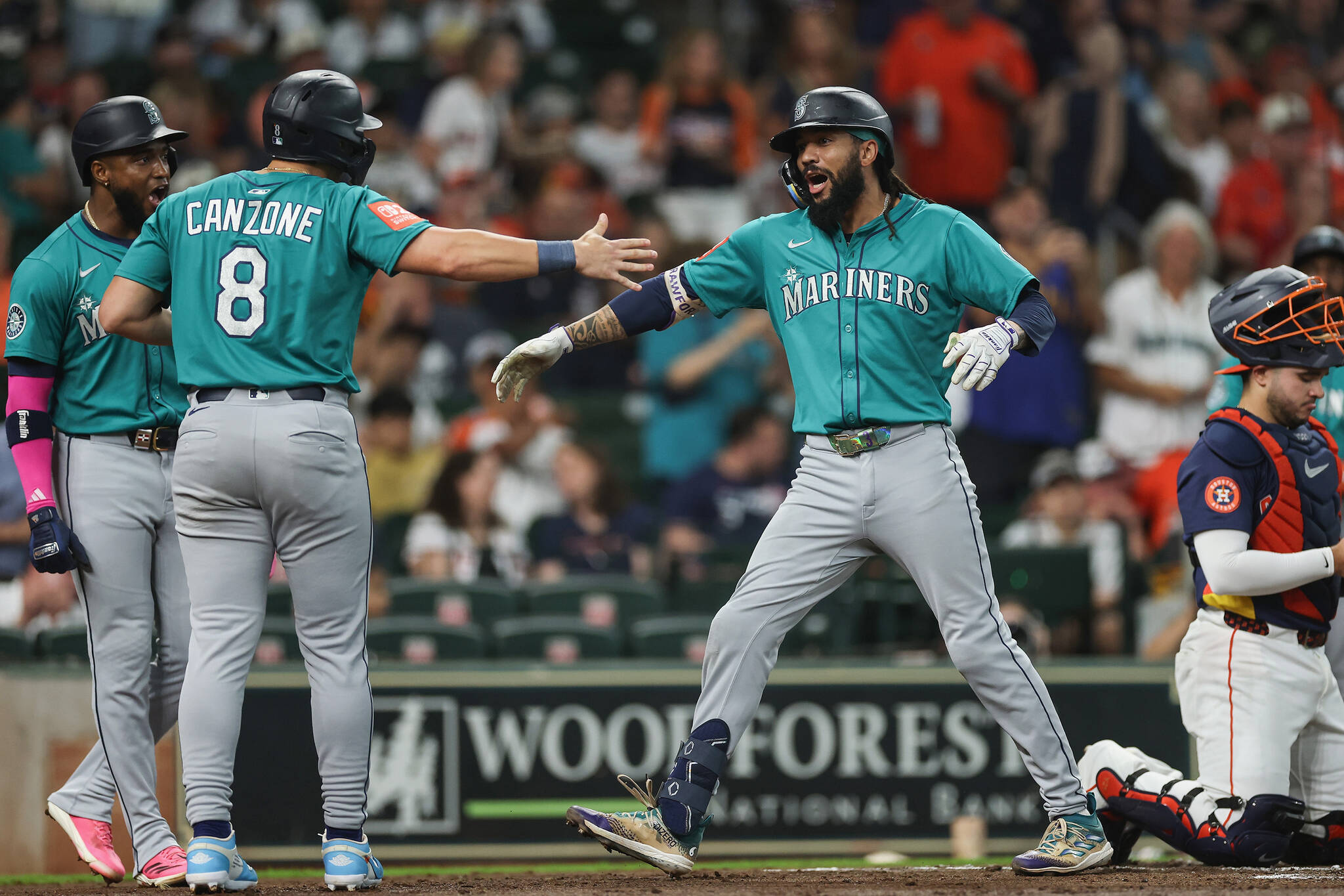J.P. Crawford (3) of the Seattle Mariners celebrates with Dominic Canzone (8) of the Seattle Mariners after hitting a grand slam in the second inning against the Houston Astros at Daikin Park on Sunday, Sept. 21, 2025, in Houston. (Tim Warner / Getty Images / Tribune News Services)