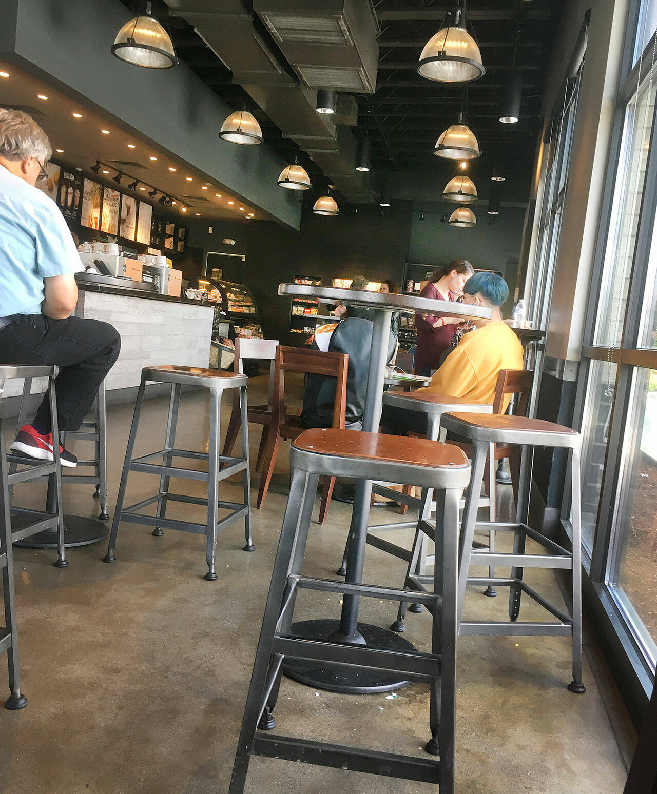 Coffee drinkers patronize Starbucks on 10th and Broadway in 2018 in Everett. (Sue Misao / The Herald)