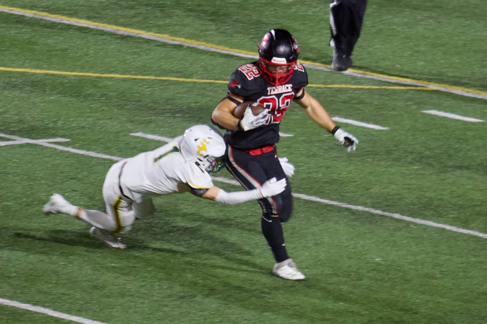 Mountlake Terrace junior Owen Boswell (22) tries to break a tackle from Shorecrest senior Michael Quigley en route to 128 rushing yards and three touchdowns in the Hawks’ 29-0 win at Edmonds Stadium in Edmonds on Sept. 26, 2025. (Joe Pohoryles / The Herald)