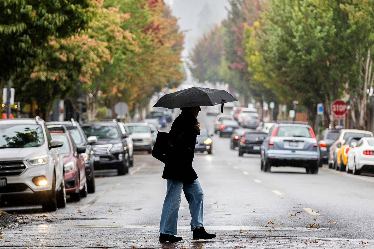 A woman crosses 5th Avenue South with an umbrella as it rains on Sept. 29, 2025 in Edmonds, Washington. (Olivia Vanni / The Herald)