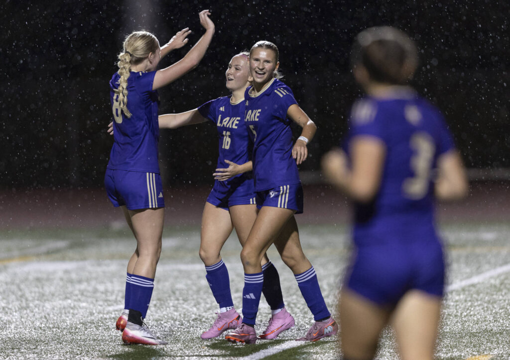 Lake Stevens’ Carley Robertson, left, Shelby Clifton, center, and Whitney Bird, right, hug after scoring a goal during the game against Kamiak on Sept. 30, 2025 in Lake Stevens, Washington. (Olivia Vanni / The Herald)
