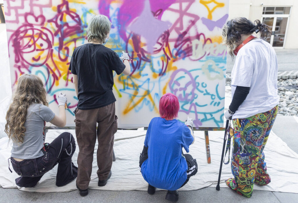A handful of teens work on a collaborative graffiti project during Teen Night at the Schack Art Center on Sept. 18, 2025 in Everett, Washington. (Olivia Vanni / The Herald)
