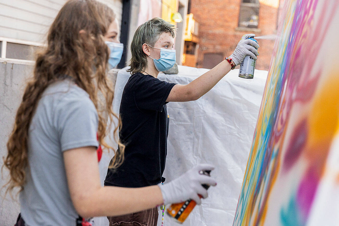 Nick Lawing, 13, right, and Kayak Pidgeon, 14, right, spray paint a canvas during Teen Night at the Schack Art Center on Sept. 18, 2025 in Everett, Washington. (Olivia Vanni / The Herald)