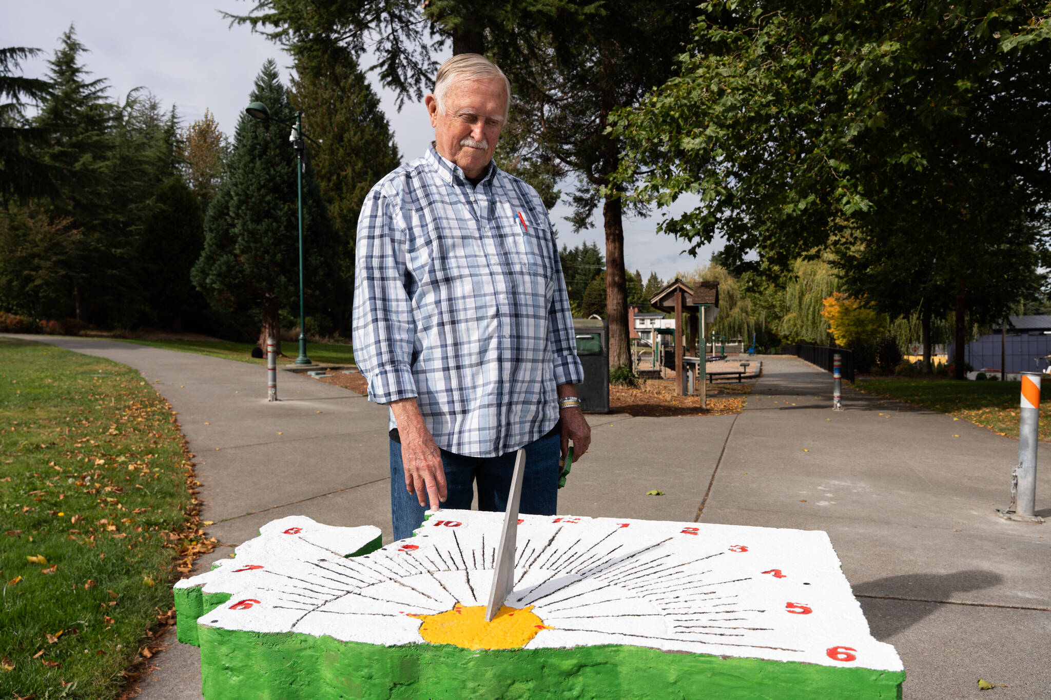 James Stegenga stands with his sundial on Tuesday, Sept. 30 in Lions Park in south Everett. (Will Geschke / The Herald)