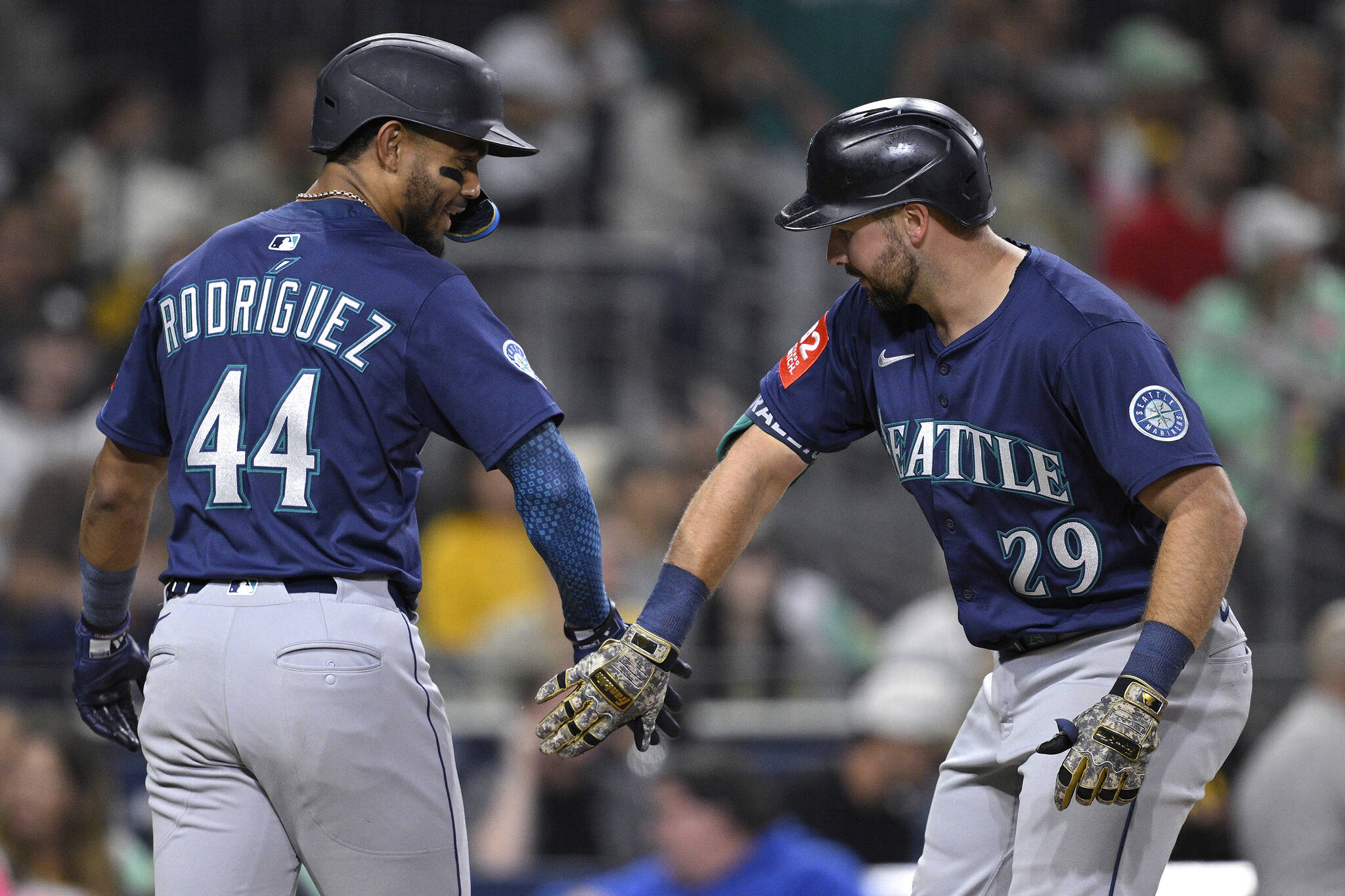 The Seattle Mariners' Cal Raleigh (29) is congratulated by Julio Rodriguez (44) after hitting a two-run home run against the San Diego Padres during the sixth inning at Petco Park on May 16, 2025, in San Diego. (Orlando Ramirez / Getty Images / Tribune News Services)