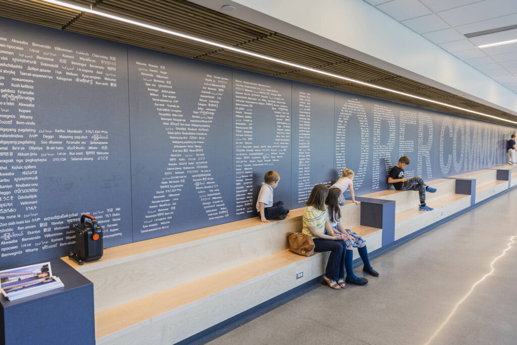 People sit on benches in the main hallway of Explorer Middle School’s new athletics building on Oct. 7, 2025 in Everett, Washington. (Olivia Vanni / The Herald)
