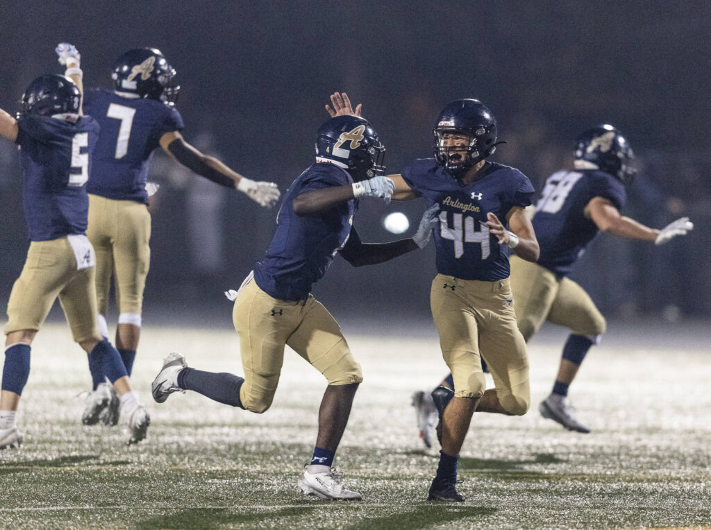 Arlington players react to recovering a turnover by Stanwood during the game on Oct. 10, 2025 in Arlington, Washington. (Olivia Vanni / The Herald)
