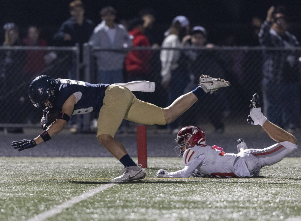 Arlington’s Shane Wohlleben dives into the end zone for a touchdown during the game against Arlington on Oct. 10, 2025 in Arlington, Washington. (Olivia Vanni / The Herald)
