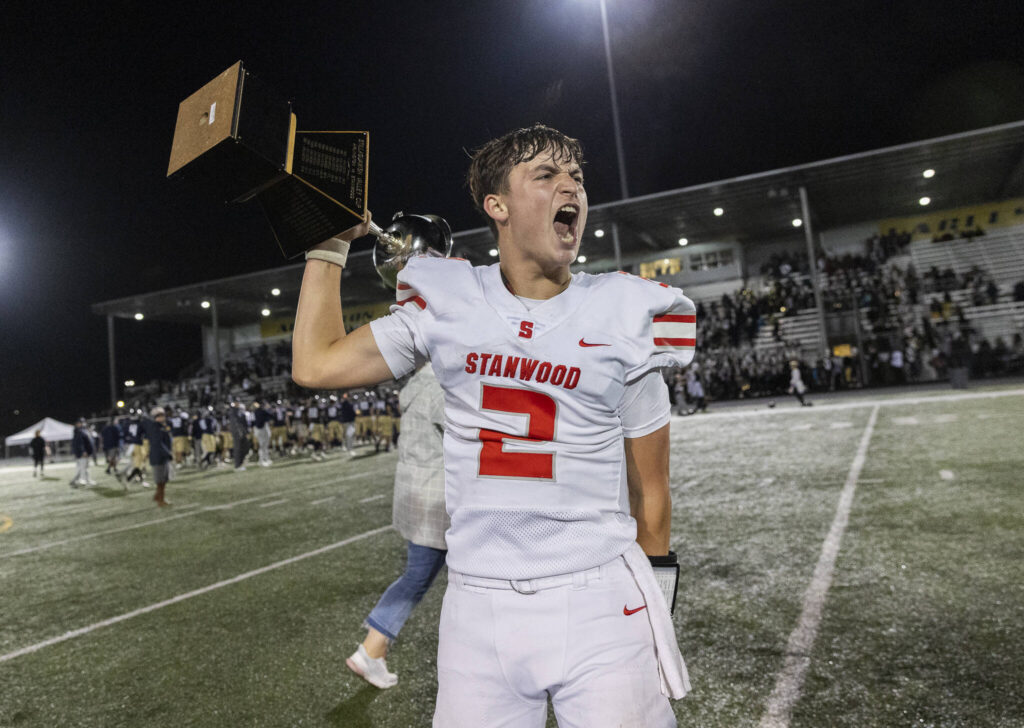 Stanwood’s Alex Maldonado yells while running with the Stilly Cup after beating Arlington on Oct. 10, 2025 in Arlington, Washington. (Olivia Vanni / The Herald)
