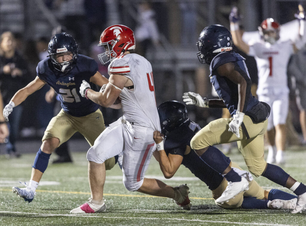 Stanwood’s Silas Turpin runs through a tackle into the end zone for a touchdown during the game against Arlington on Oct. 10, 2025 in Arlington, Washington. (Olivia Vanni / The Herald)

