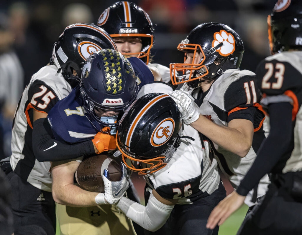 Granite Falls’ Angel Hernandez and Blake Hudson tackle Cedar Park Christian’s Lincoln Meyers during the game on Oct. 24, 2025 in Kirkland, Washington. (Olivia Vanni / The Herald)