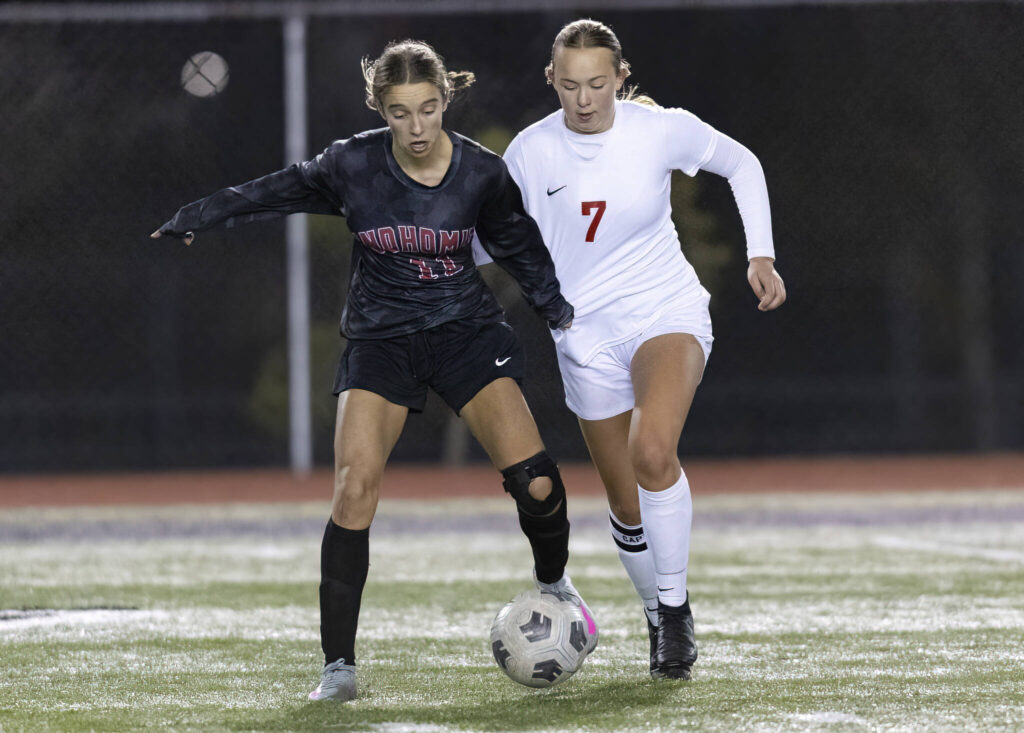 Snohomish’s Jenna Pahre and Stanwood’s Mylee LaComb grab each others jerseys while running after the ball during the game on Oct. 27, 2025 in Snohomish, Washington. (Olivia Vanni / The Herald)