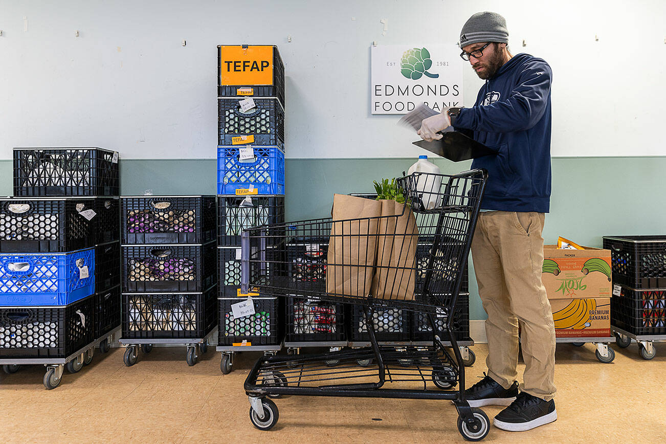 Lester Almanza, programs manager at the Edmonds Food Bank, puts together a custom shoppers order on Wednesday, March 26, 2025 in Edmonds, Washington. (Olivia Vanni / The Herald)