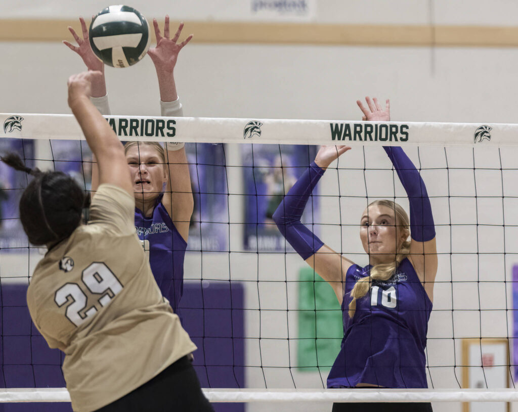 Lynnwood’s Makena Kaleo spikes the ball over the net while Edmonds-Woodway’s Eva Belova and Raina Wilson jump up to block during the game on Oct. 29, 2025 in Edmonds, Washington. (Olivia Vanni / The Herald)
