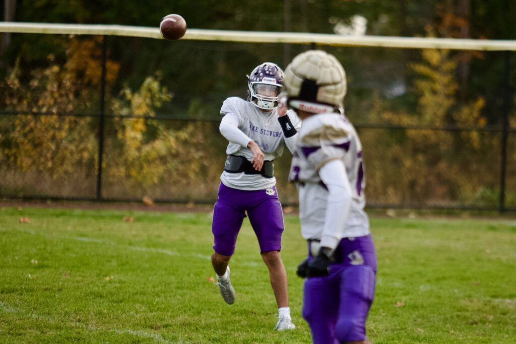 Lake Stevens junior Blake Moser airs out a pass to a receiver in the foreground during a Vikings practice at Lake Stevens High School on Oct. 29, 2025. (Joe Pohoryles / The Herald)
