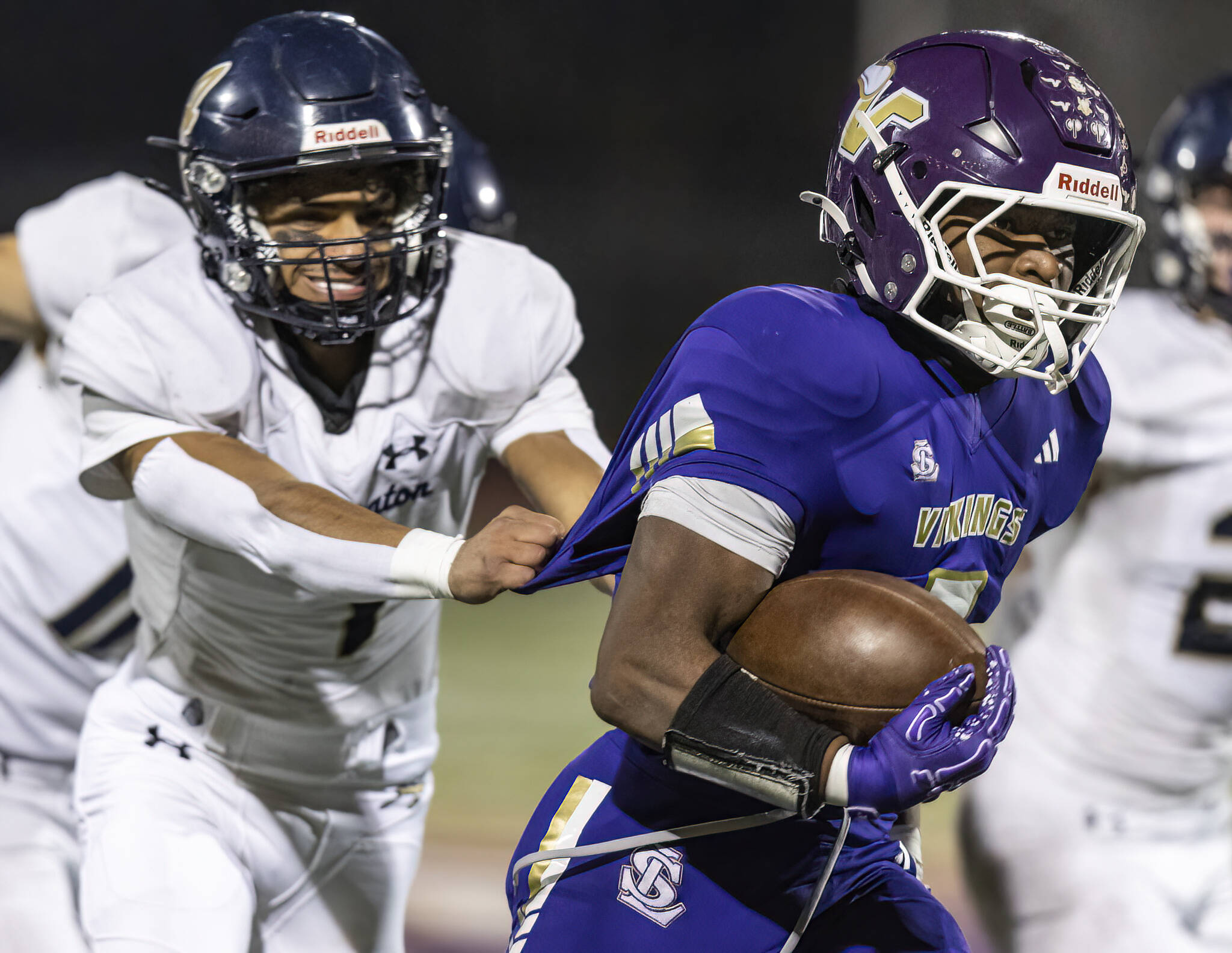 Lake Stevens Jayvian Ferrell has his jersey pulled as he runs the ball upfield during the game against Arlington on Oct. 31, 2025 in Lake Stevens, Washington. (Olivia Vanni / The Herald)