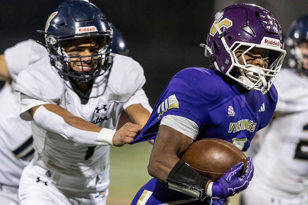 Lake Stevens’ Jayvian Ferrell has his jersey pulled as he runs the ball upfield during the game against Arlington on Oct. 31, 2025 in Lake Stevens, Washington. (Olivia Vanni / The Herald)