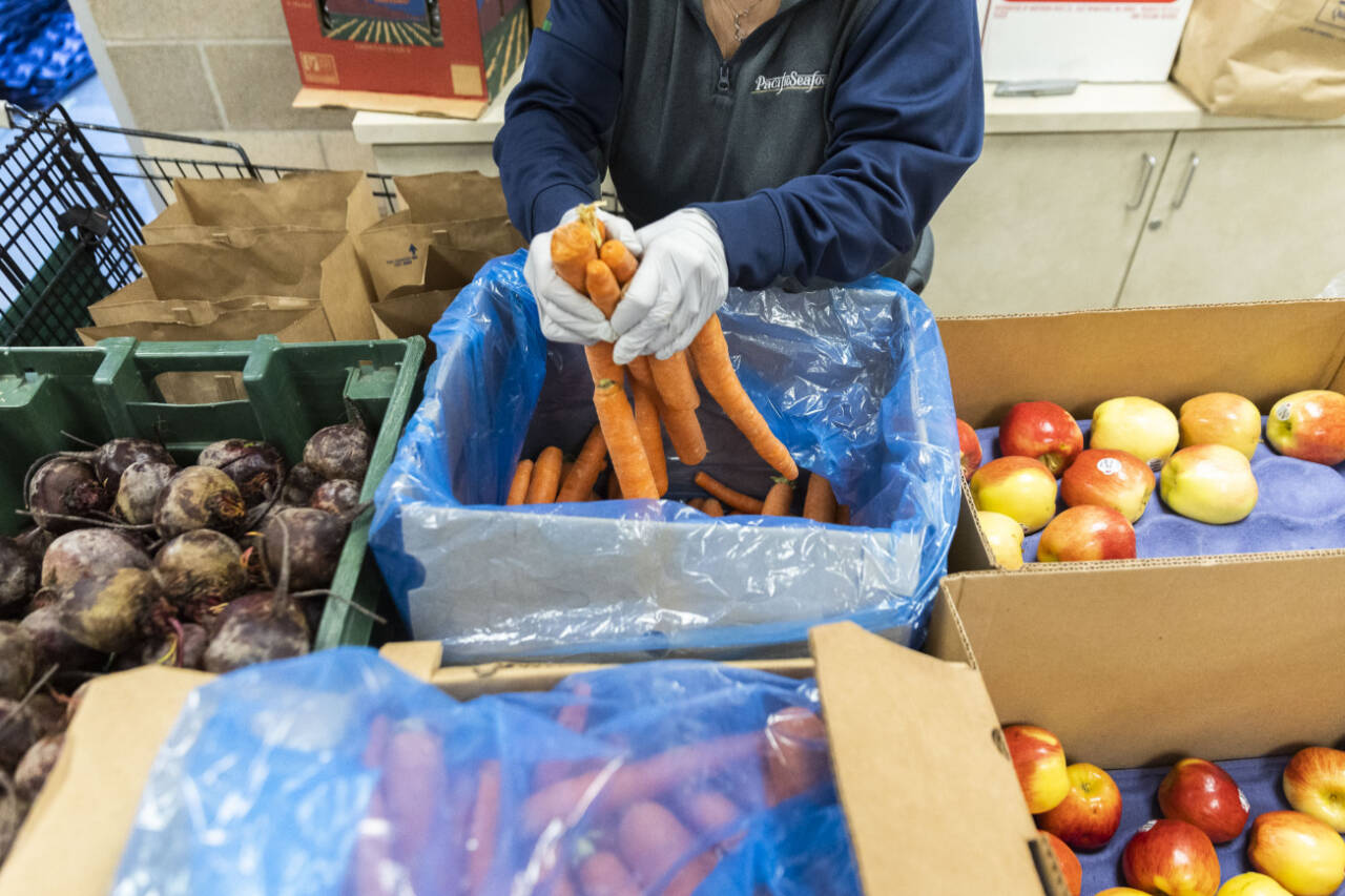 Fresh produce is placed in bags at the Mukilteo Food Bank on Nov. 25, 2024, in Mukilteo. (Olivia Vanni / The Herald file photo)