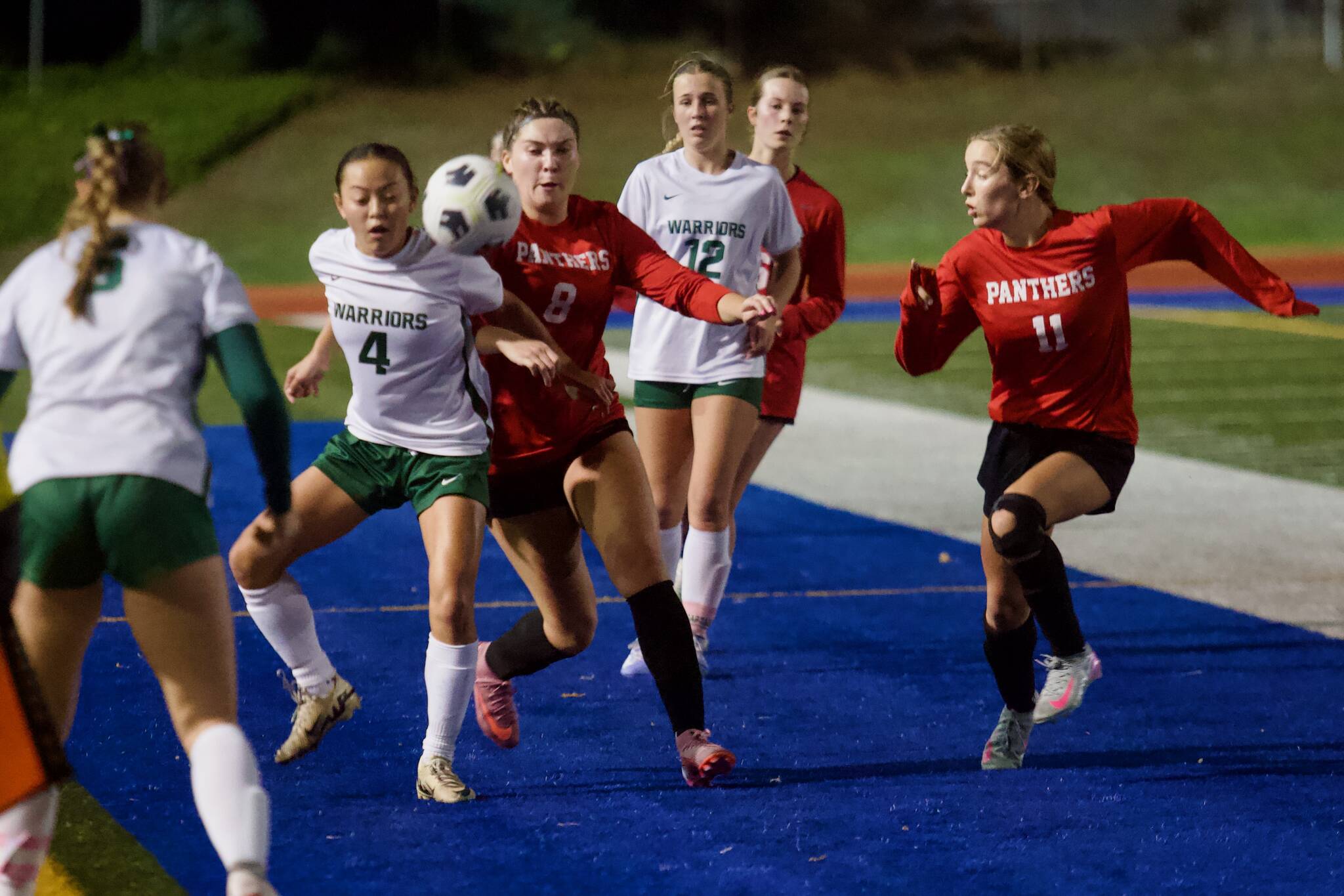 Snohomish junior Danica Avalos (8 in red) and Edmonds-Woodway junior Akiko Ikegami (4 in white) jostle to win possession of a throw-in during the Panthers' 2-0 win against the Warriors in the District 1 3A semifinals at Shoreline Stadium on Nov. 4, 2025. (Joe Pohoryles / The Herald)