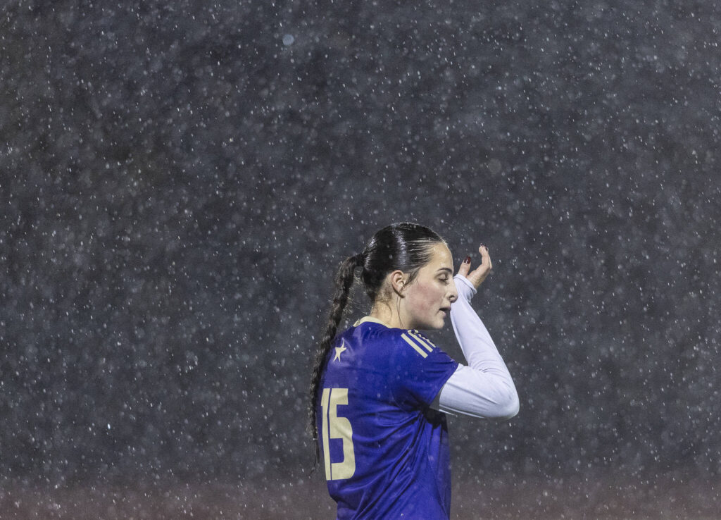 Lake Stevens’ Judith Roehl wipes her face as rain continues to fall during the 4A girls district game against Jackson on Nov. 5, 2025 in Lake Stevens, Washington. (Olivia Vanni / The Herald)

