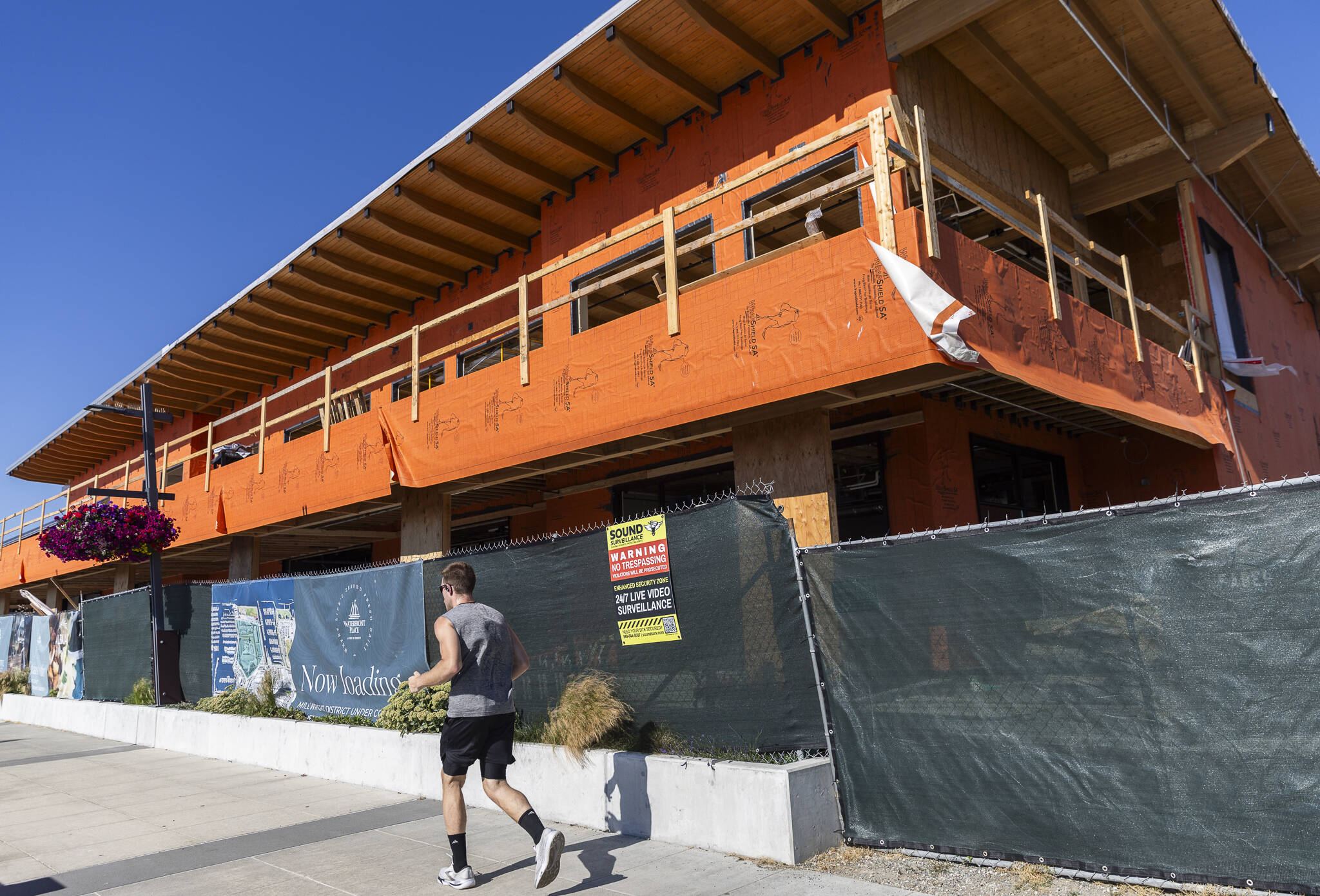A runner jogs past construction in the Port of Everett’s Millwright District on Tuesday, July 15, 2025 in Everett, Washington. (Olivia Vanni / The Herald)