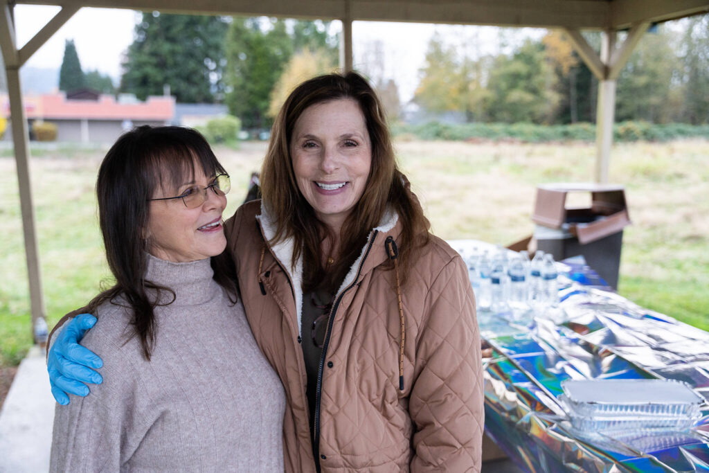 Penelope Protheroe, left, the president of Angel Resource Connection, and Carie Claxton, a board member for the nonprofit, at the food distribution on Monday, Nov. 10 in Granite Falls, Washington. (Will Geschke / The Herald)
