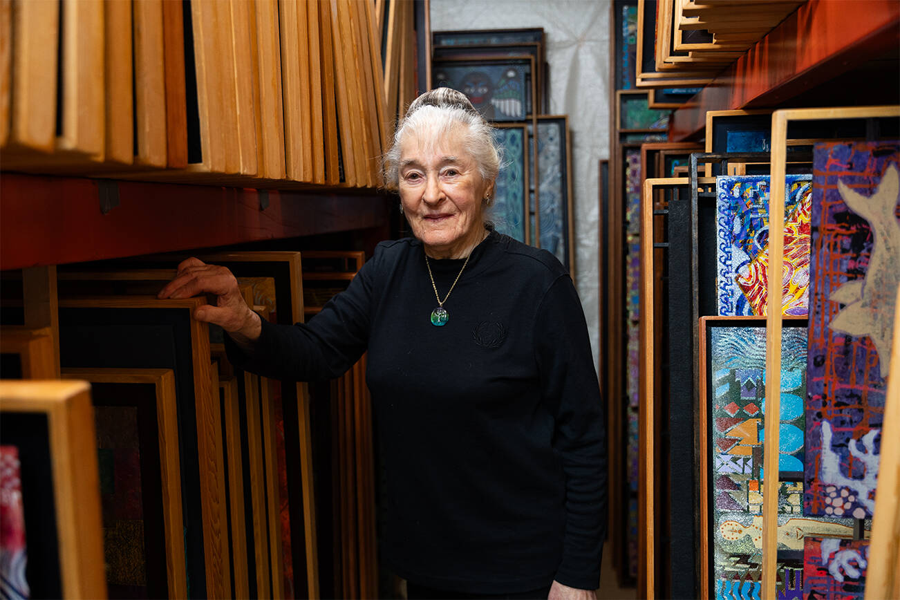 d’Elaine Herard Johnson poses for a portrait next to hundreds of her paintings in her Edmonds home on Wednesday, Nov. 12, 2025 in Edmonds, Washington. (Will Geschke / The Herald)