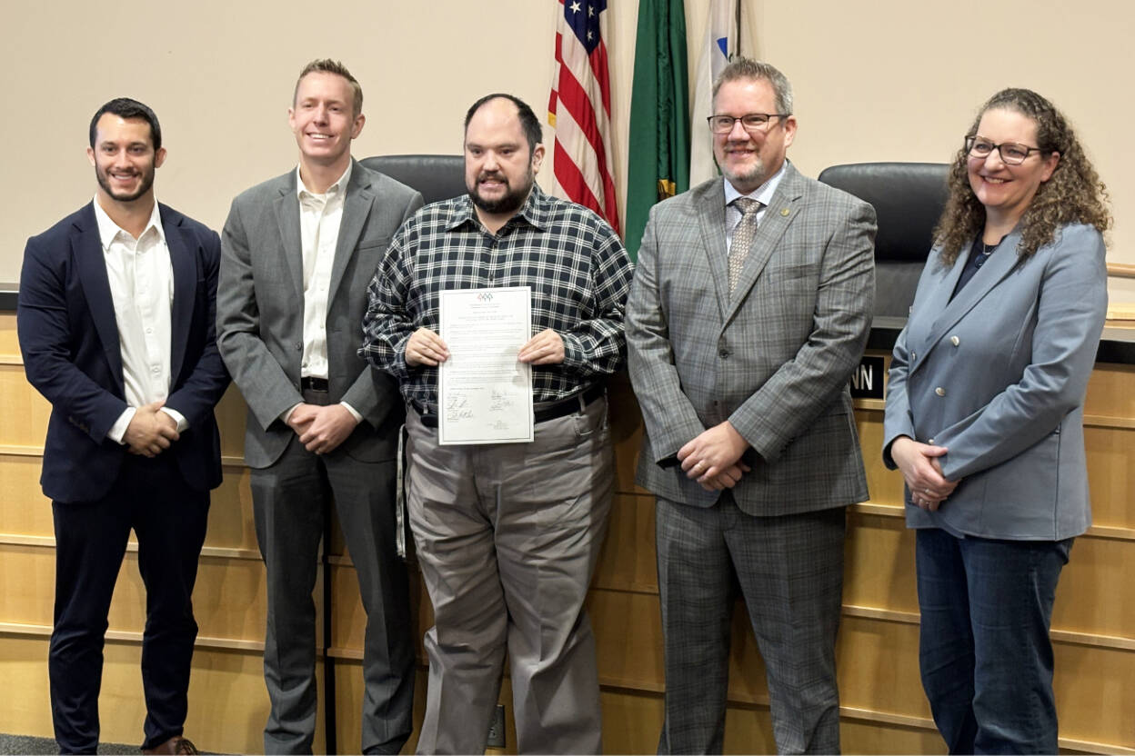 Preston Dwoskin stands with the Snohomish County Council holding a resolution acknowledging his work on the Buddy Bowl and in bullying prevention on Nov. 12, 2025. (Taylor Scott Richmond / The Herald)