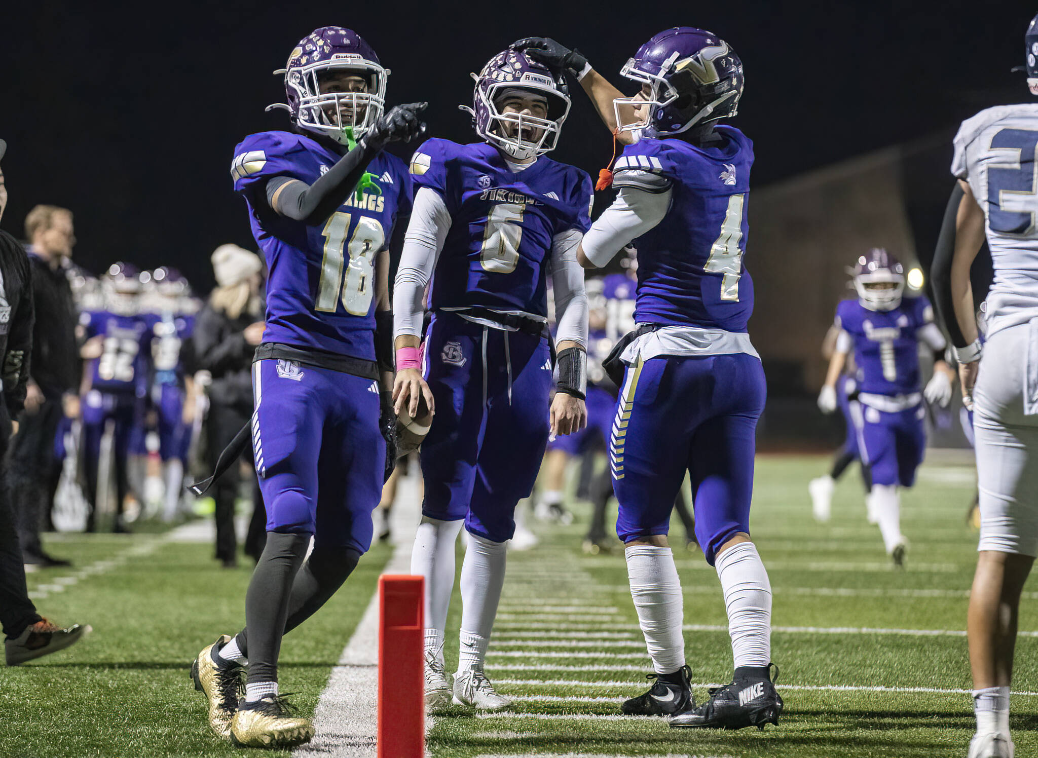 Lake Stevens' Jayden Hollenbeck (18), Blake Moser (6) and Seth Price (4) celebrate a touchdown during the game against Arlington on Oct. 31, 2025 in Lake Stevens, Washington. (Olivia Vanni / The Herald)