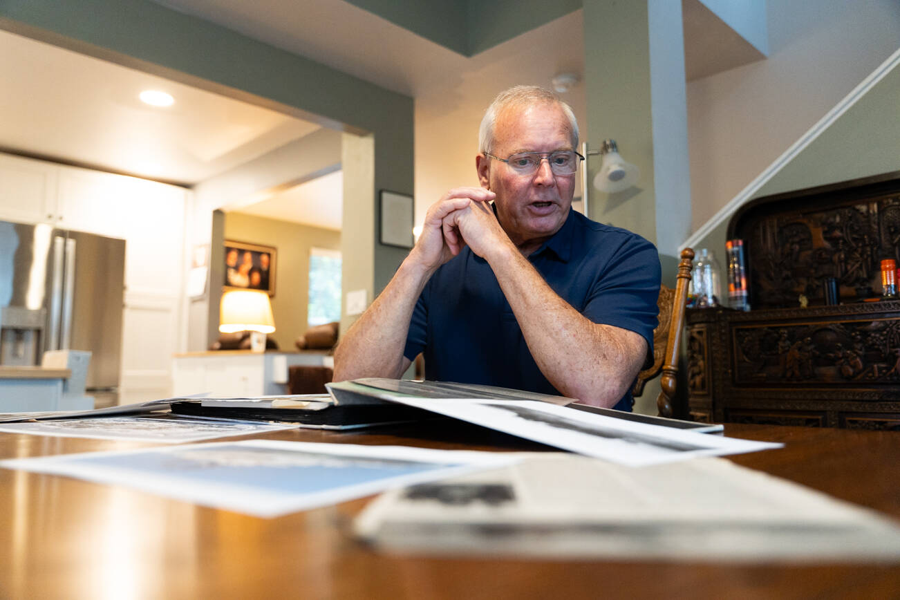 Roger Sharp looks over memorabilia from the USS Belknap in his home in Marysville on Nov. 14, 2025. (Will Geschke / The Herald)