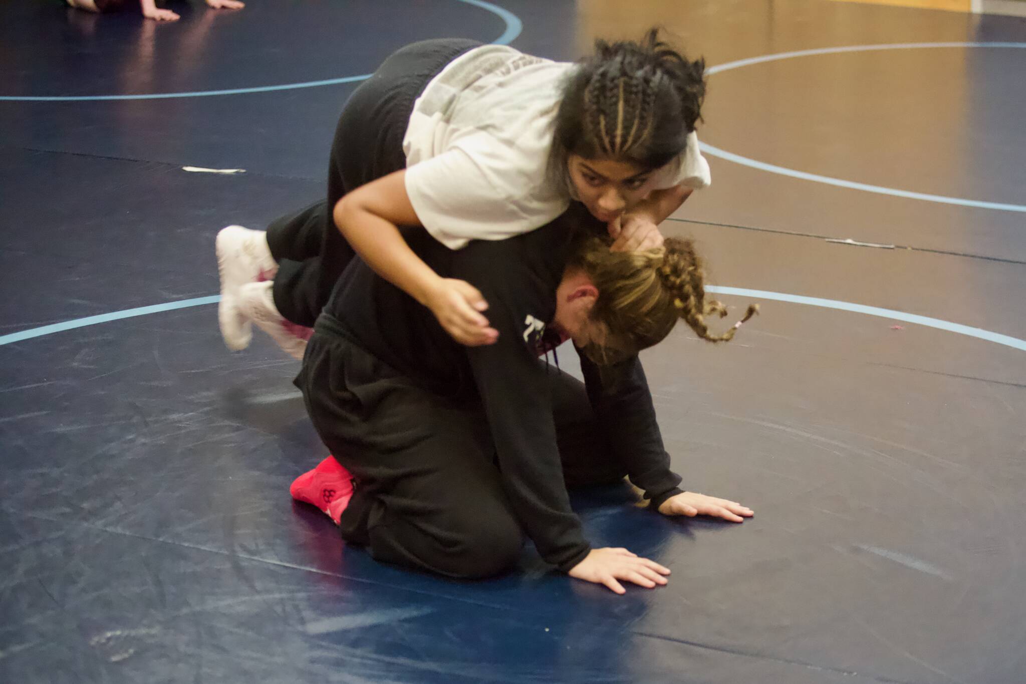 Kamiak sophomore Navami Nambiar (wearing white) and junior Lillian Burgess participate in spin drills during the first girls wrestling practice of the season at Kamiak High School on Nov. 17, 2025. (Joe Pohoryles / The Herald)