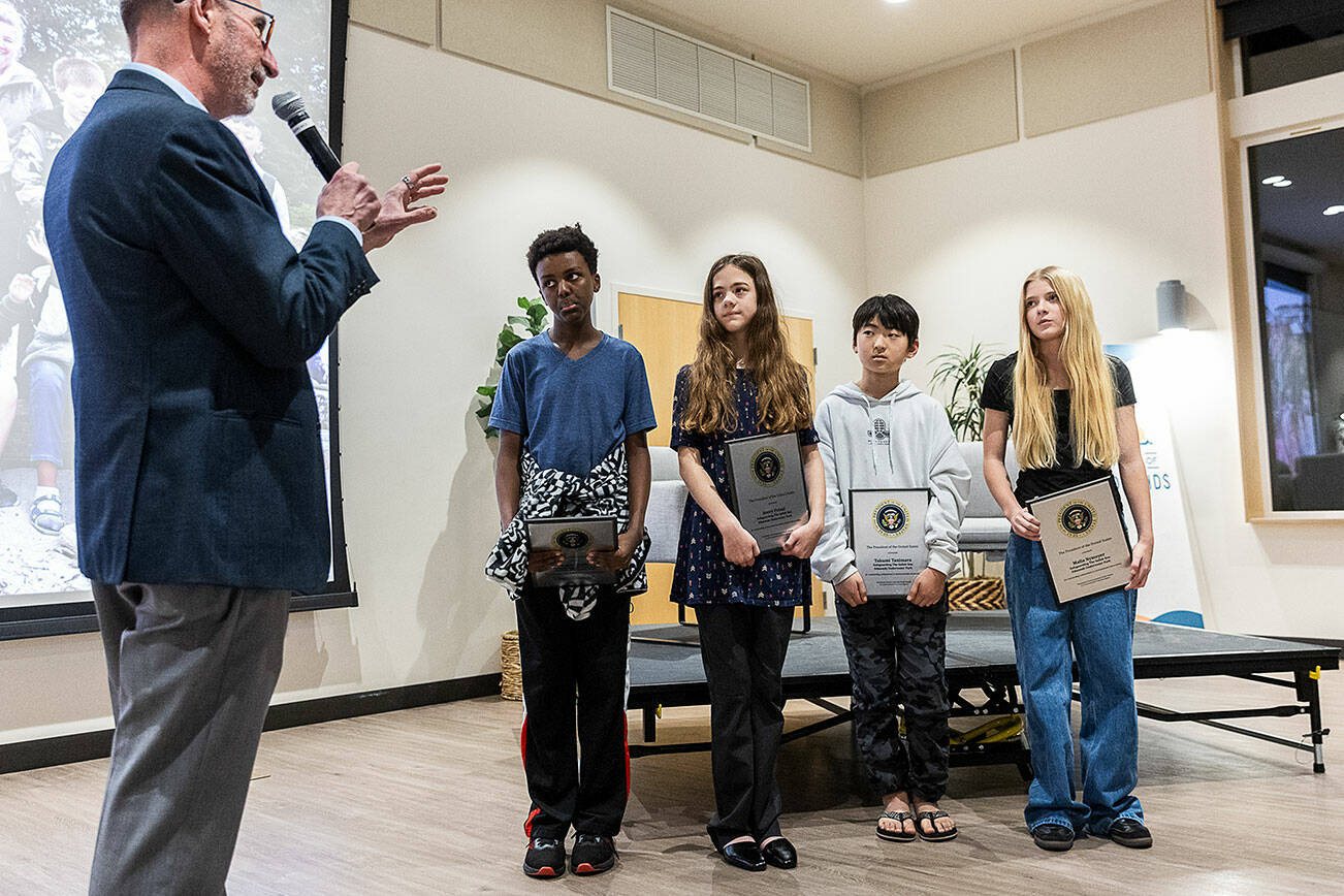 Edmonds Mayor Mike Rosen congratulates Kaleb Wolde (left to right), Avery Postal, Takumi Tanimara and Malia Nymeyer, on winning the President’s Environmental Youth Award that recognizes outstanding K-12 youth environmental stewardship projects across the nation on Nov. 20, 2025 in Edmonds, Washington. (Olivia Vanni / The Herald)