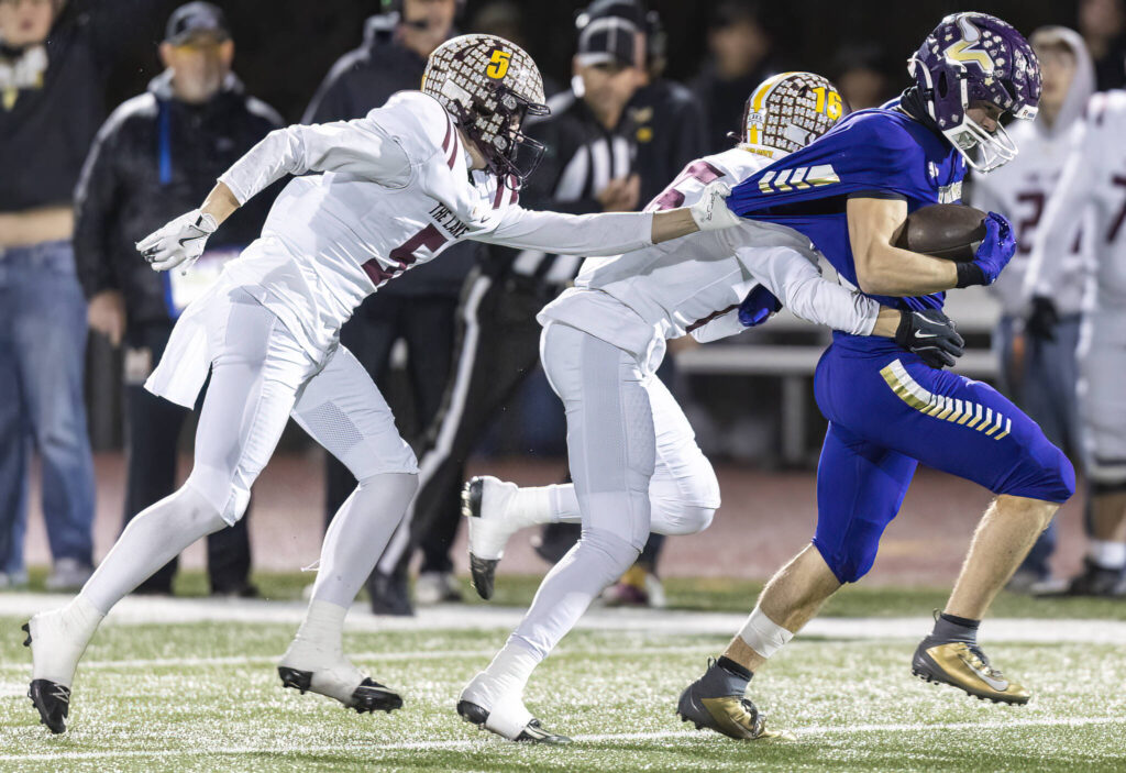 Lake Stevens’ Greyson Eggers has his jersey pulled as he runs the ball upfield during the 4A state football quarterfinal game against Moses Lake on Nov. 22, 2025 in Lake Stevens, Washington. (Olivia Vanni / The Herald)

