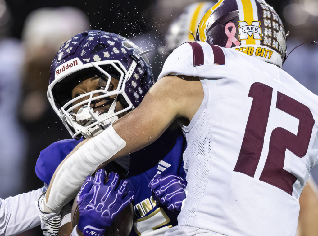 Water sprays off of Lake Stevens’ Jayvian Ferrell as he is tackled during the 4A state football quarterfinal game against Moses Lake on Nov. 22, 2025 in Lake Stevens, Washington. (Olivia Vanni / The Herald)
