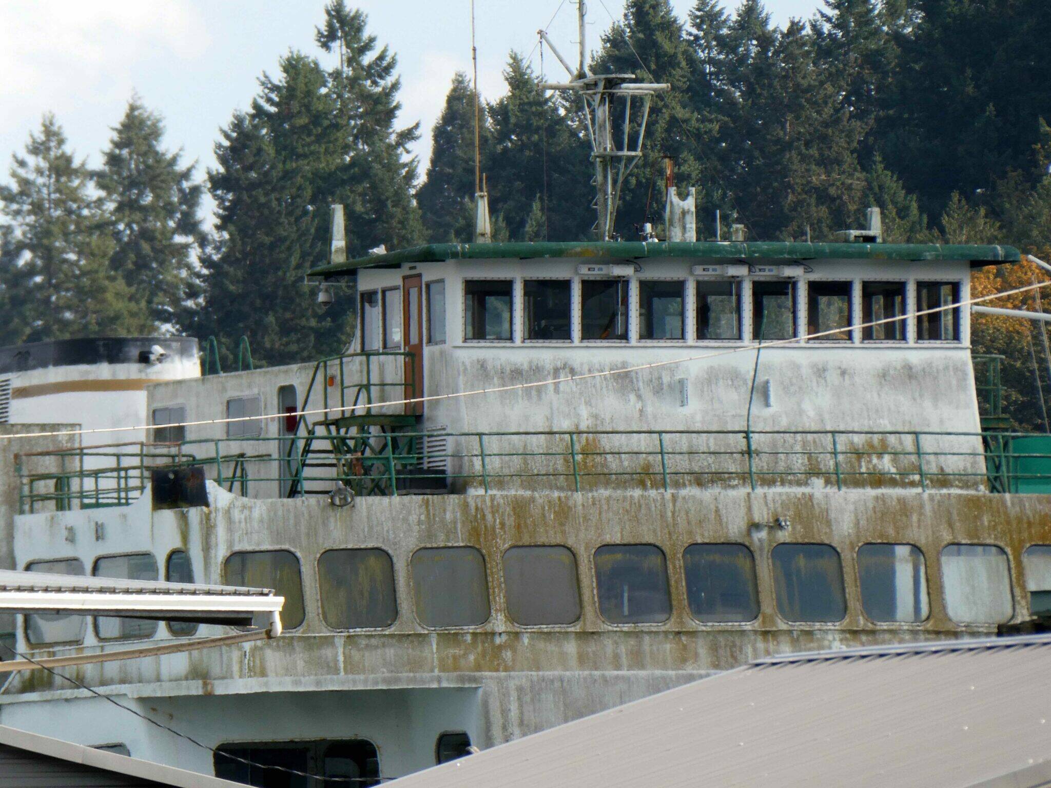 The retired state ferry Hyak is accumulating moss and grime while it sits on the market awaiting a new owner. The boat is shown moored in Eagle Harbor in late October 2025. (Photo by Tom Banse for Washington State Standard)