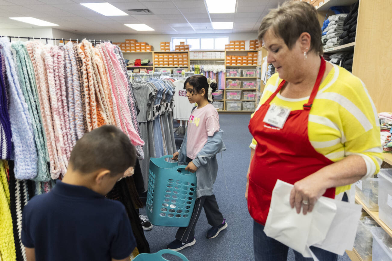 Aleen Alshamman carries her basket as she picks out school clothes with the help of Operation School Bell volunteers on Sept. 24, 2025 in Everett, Washington. (Olivia Vanni / The Herald)