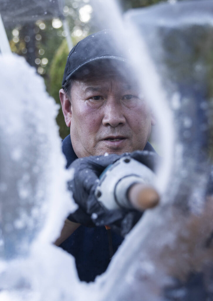 Kitburi makes small adjustments to his ice sculpture while he works on Sept. 17, 2025 in Marysville, Washington. (Olivia Vanni / The Herald)
