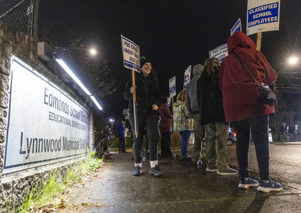 Lauren Johnson joins people rallying outside of the Edmonds School District building before a school district meeting on Tuesday, Dec. 9, 2025, in Edmonds, Washington. (Olivia Vanni / The Herald)
