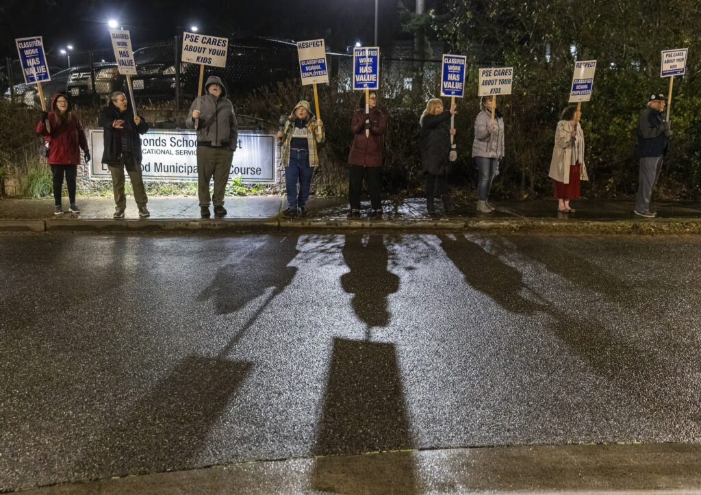 People line the sidewalk outside of the Edmonds School District building on Tuesday, Dec. 9, 2025, in Edmonds, Washington. (Olivia Vanni / The Herald)
