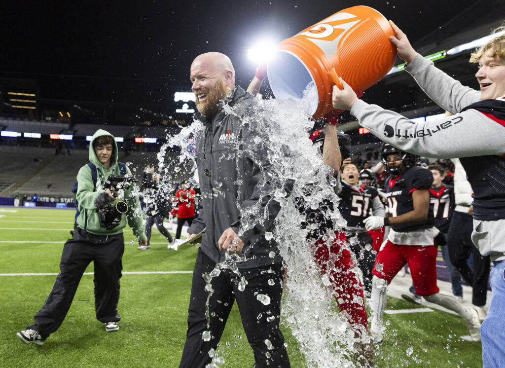 Archbishop Murphy head coach Joe Cronin has ice water dumped on him after winning the 2A state championship game against Tumwater at Husky Stadium on Saturday, Dec. 6, 2025 in Seattle, Washington. (Olivia Vanni / The Herald)
